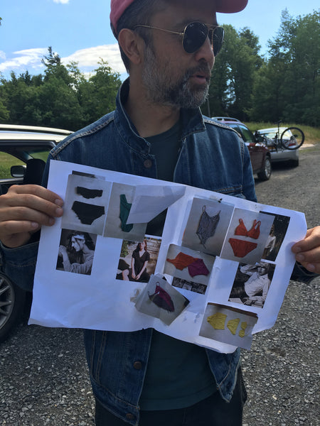 Man holding up images of lingerie on paper.