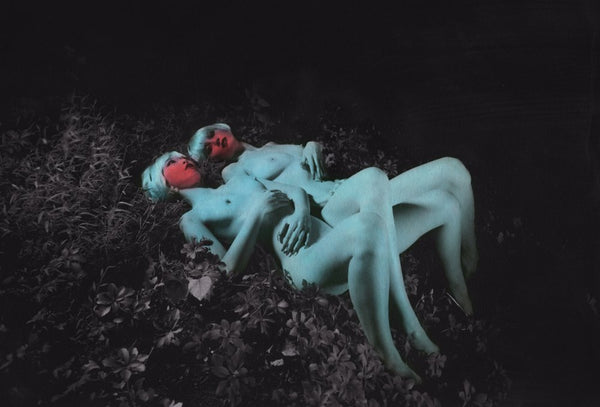 Two naked women with blue bodies laying against each other.