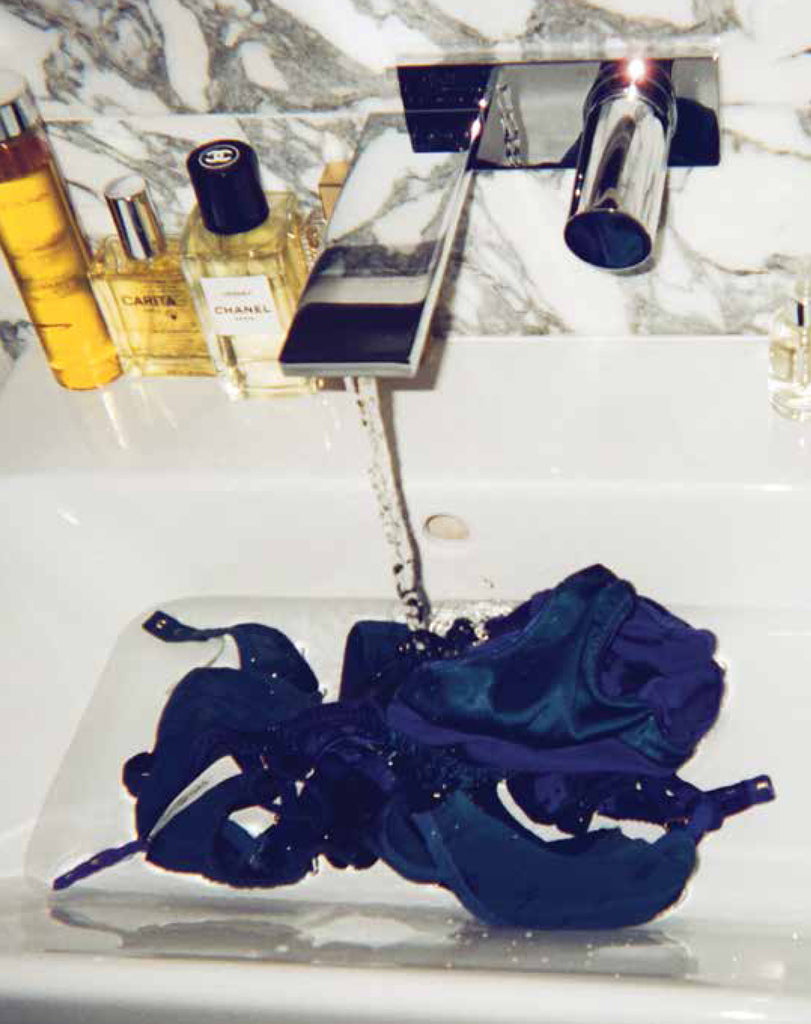 Blue lingerie being washed in a sink.