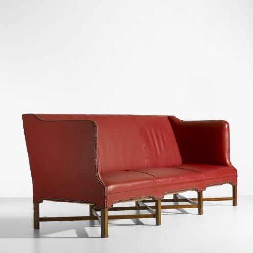 Red leather couch with brown legs.