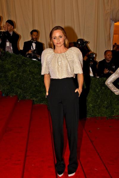 Stella McCartney in a white sequined shirt and high waisted black pants on red steps
