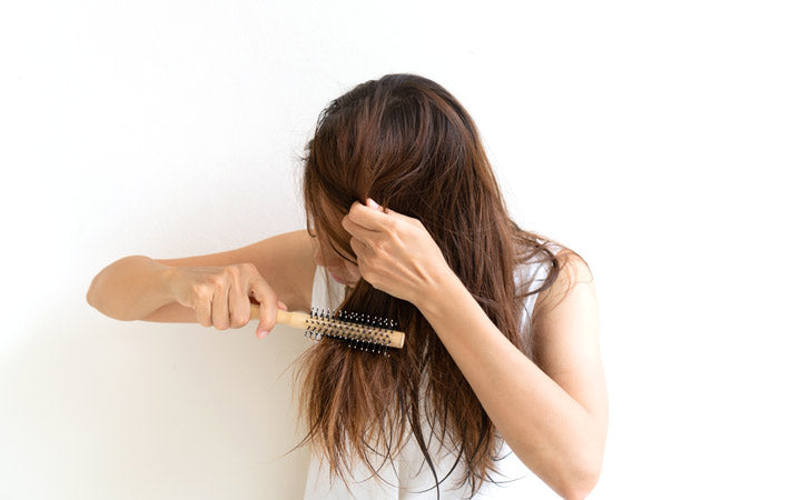 woman brushing wet messy hair