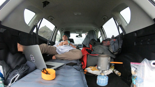 Pete sleeping in a car on his Luno camping air mattress.