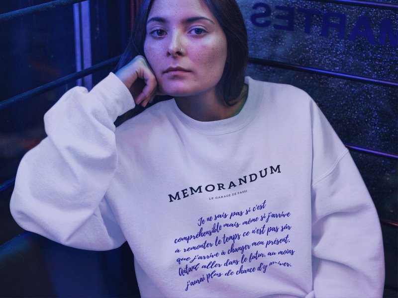 Femme portant un sweatshirt blanc imprimé sur le devant du texte "memorandum" de la marque LGF