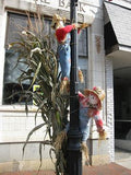 Two Scarecrows Climbing A Lamp Post