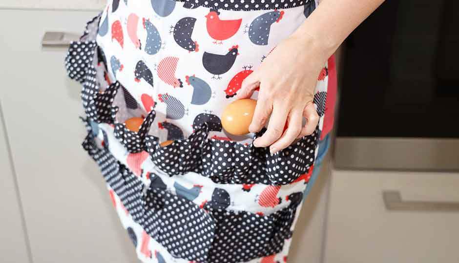 woman wearing egg collecting chicken print apron 