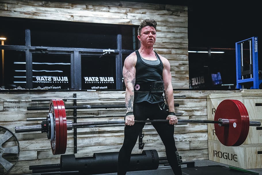 Fit man doing deadlift exercise in gym