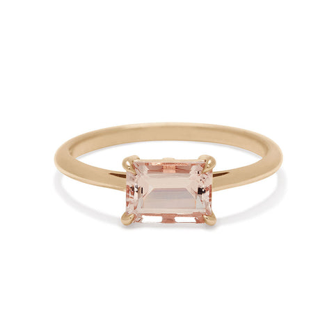 An east/west solitaire ring with an emerald shape pink morganite stone set in yellow gold. 3
