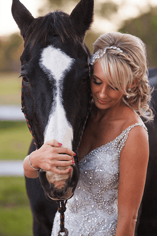 Woman in wedding dress posing next to brown horse_photo by Blue Tulip Imaging