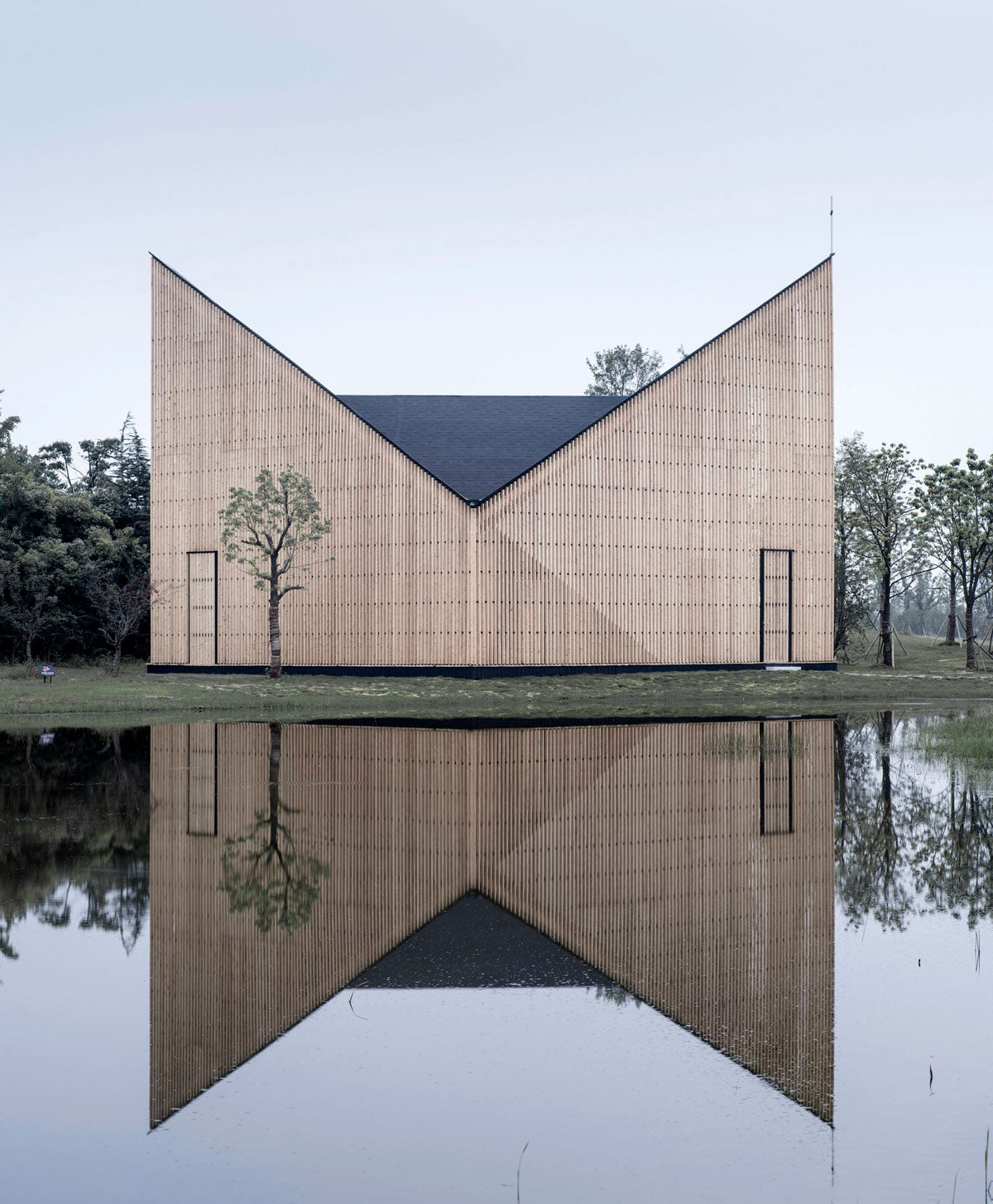 La capilla Nanjing Wanjing Garden tiene 200 metros cuadrados y se encuentra en Wanjing Garden, a lo largo de la orilla del río Nanjing en China. Elaborada con una estructura de madera y acero tiene una forma exterior suave, así como un espacio interior fuerte y de textura lisa, por AZL Architects.  Foto: Yao Li