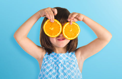 girl, orange, vitamin c, wellvites kids vitamins