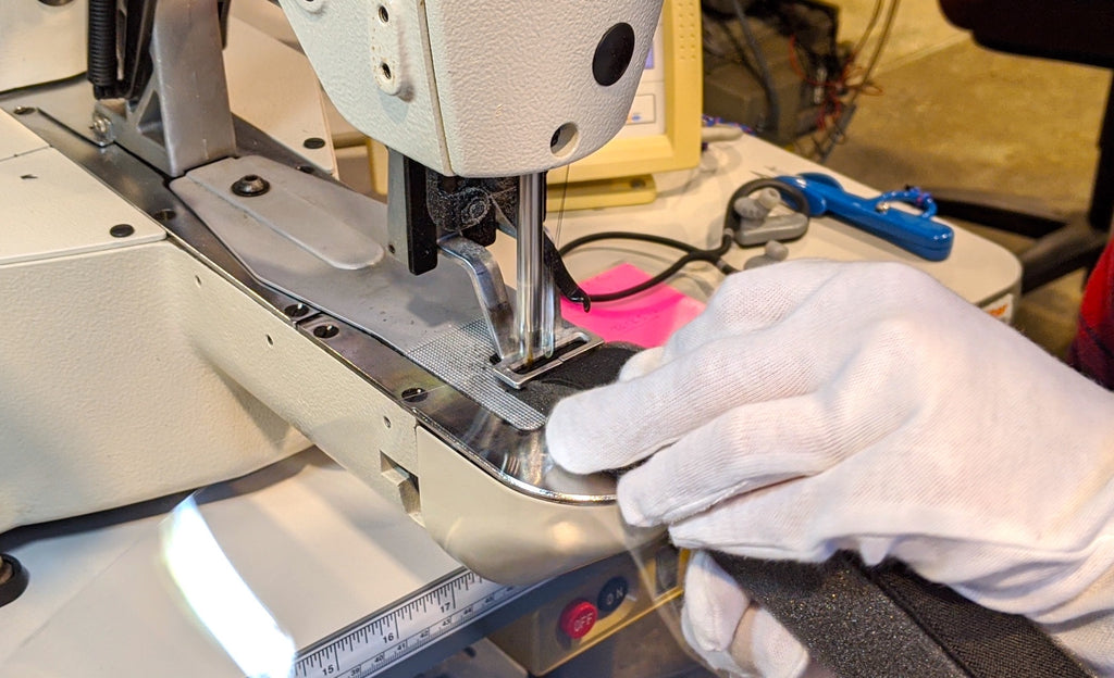 flowfold employee sews protective face shields while wearing protective sterile gloves