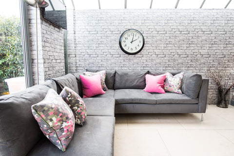 large kitchen sofa with brick wallpaper bright pink cushions