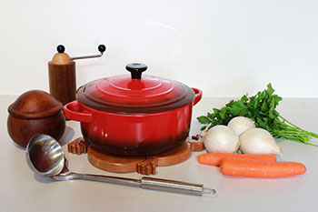 Photo of cooking pot on a trivet and other utensils