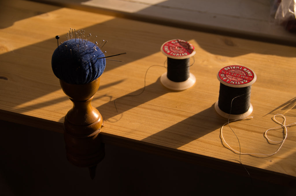 Pincushion and sewing threads by the window