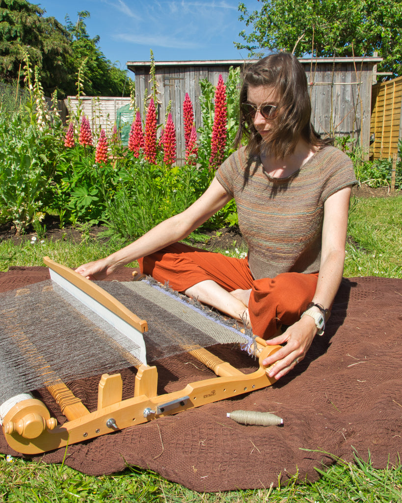 Weaving on a rigid heddle loom in the garden