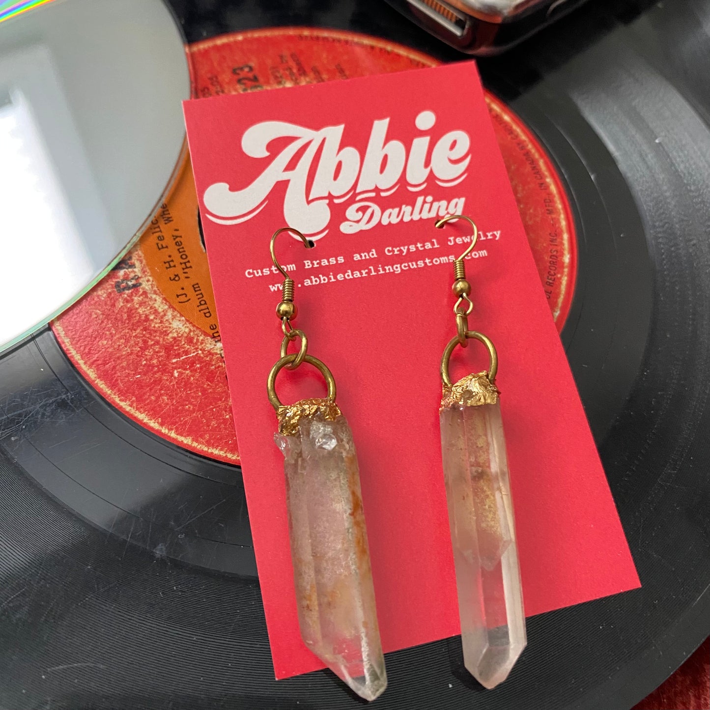 Inclusion quartz wands dangle off of brass hoops fixed to fish hook earrings