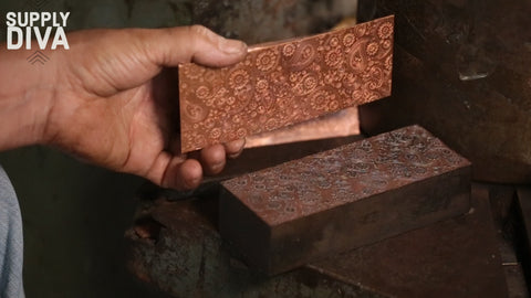 A textured sheet of metal is removed from the dye