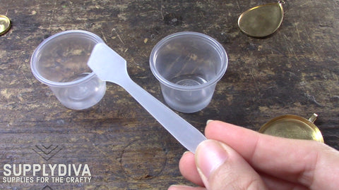 Small plastic cups and spatula used to mix resin