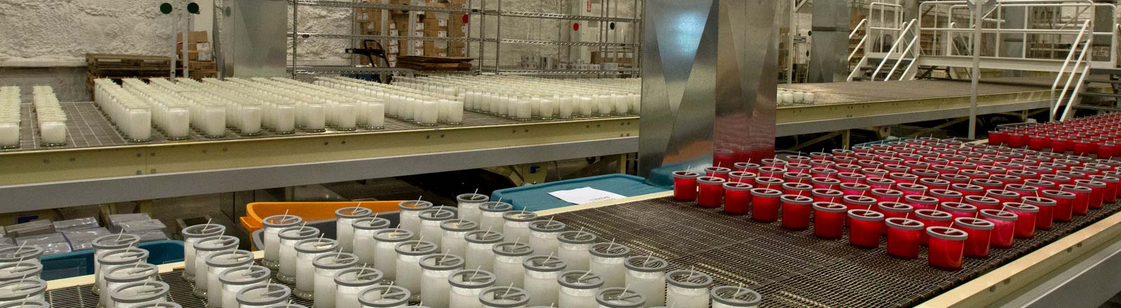 Photo of Kringle Candle's manufacturing facility in Bernardston, Massachusetts, showing candle jars on a conveyor belt.