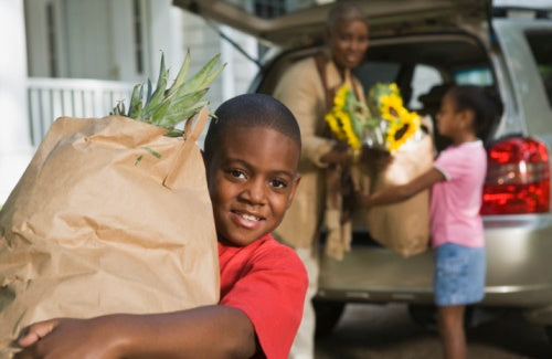 Smiling boy with family and groceries,raising great kids