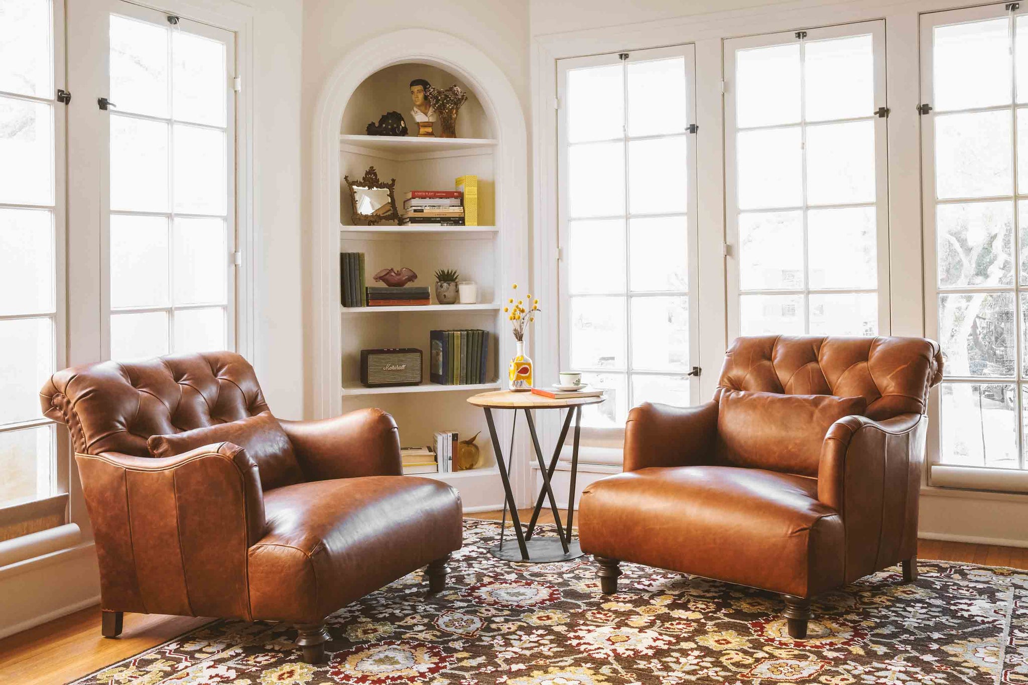  Leather chairs in Spur Terracotta in a white room sitting in front of large windows. 