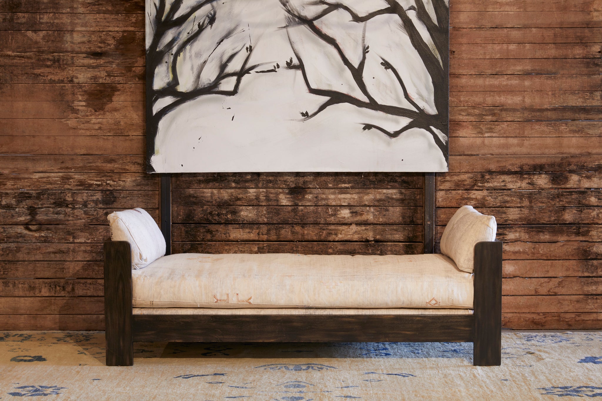  室内木墙，以复古Kilim Grey的卡森72沙发床为特色 