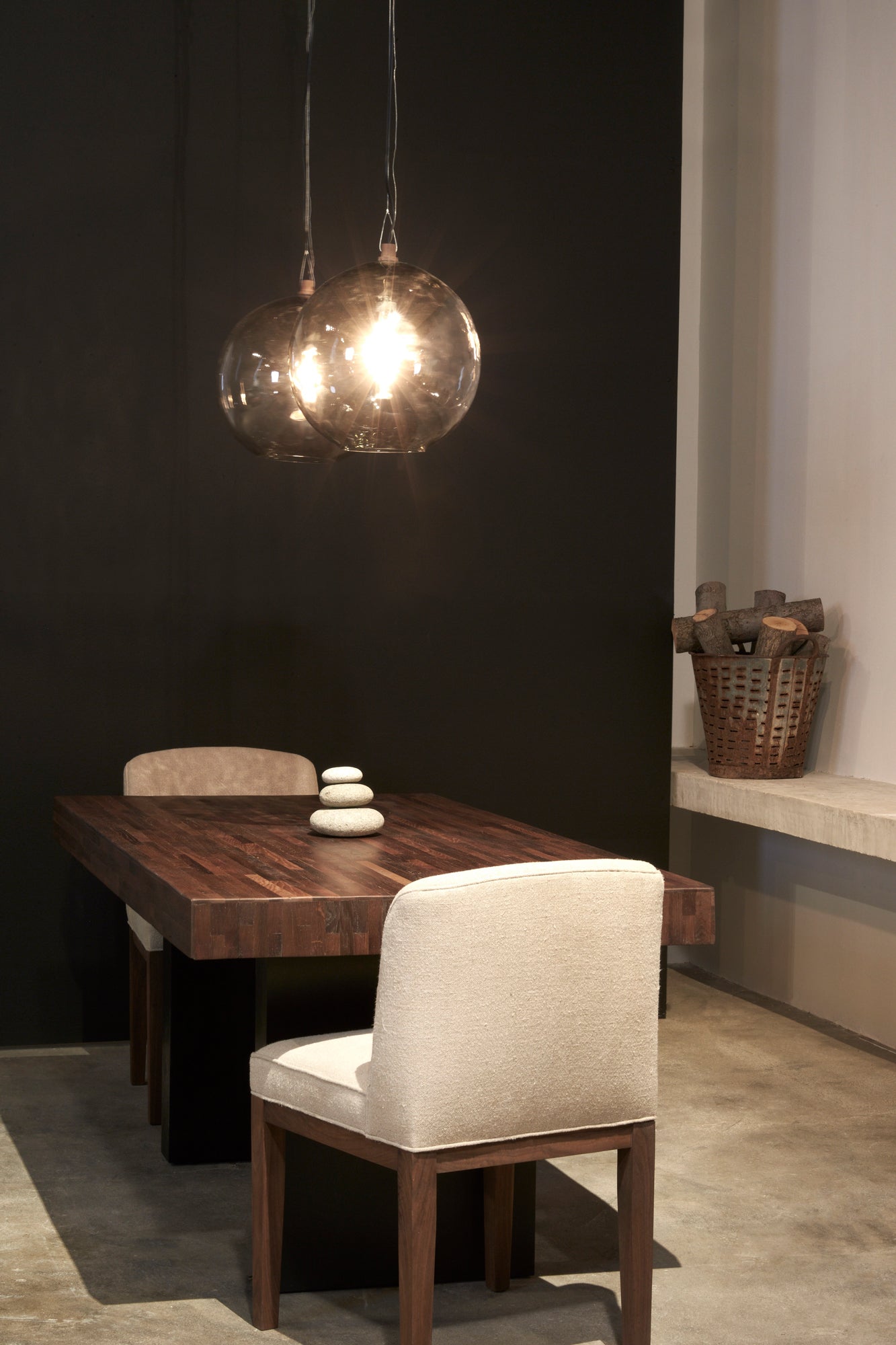  餐厅配有木制餐桌, 两把白色织物的软垫椅子和两个球形吊坠悬挂在餐桌上方.  
