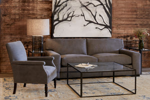  在Molino石板椅旁边的沙发和咖啡桌. 背景是一面木墙和一幅画. 