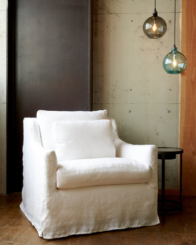 白色织物的沙发椅与转子边桌和两个小壶灯悬挂在烟和绿松石完成. 