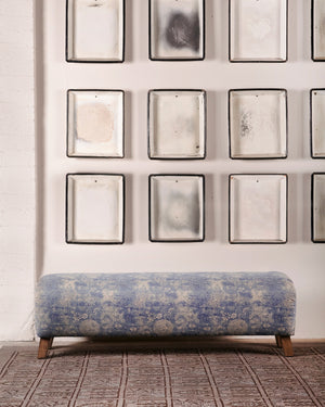  靛蓝Mariko的梅森长椅. 背景是挂在白色墙上的多个帧. 