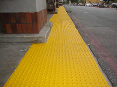 Long line of yellow truncated domes outside a store