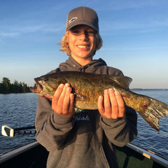 Youth in Lund boat holding Rainy Lake smallmouth bass - Voyageurs National Park