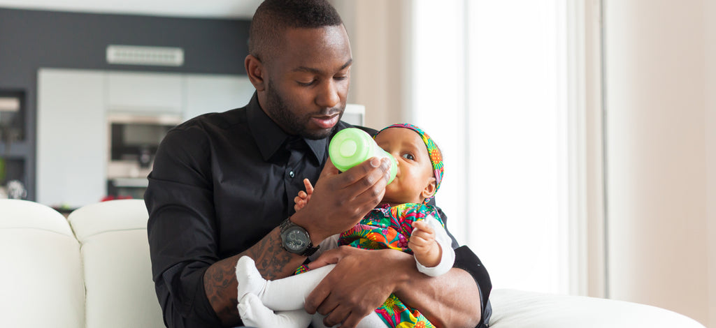 Father feeding a child with organic baby formula