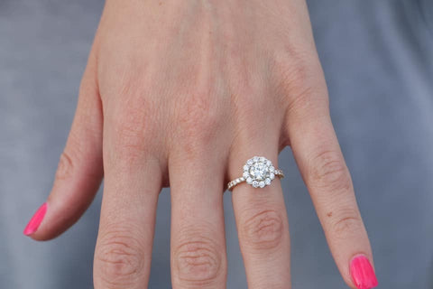 Custom engagement ring featuring a round center stone diamond with .75cttw round diamond halo and shank.