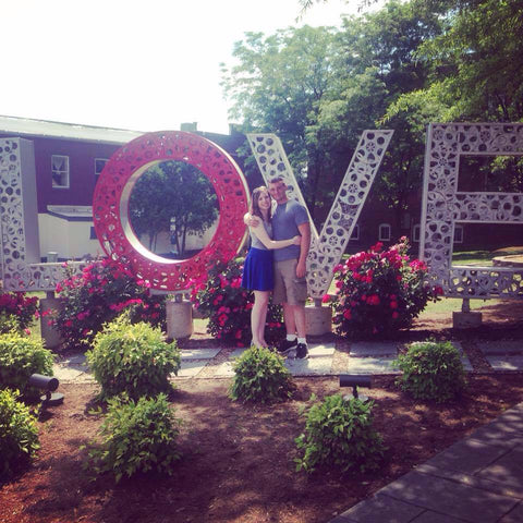 Photo of Engaged Couple Justin and Bridget Beside a Love Sign