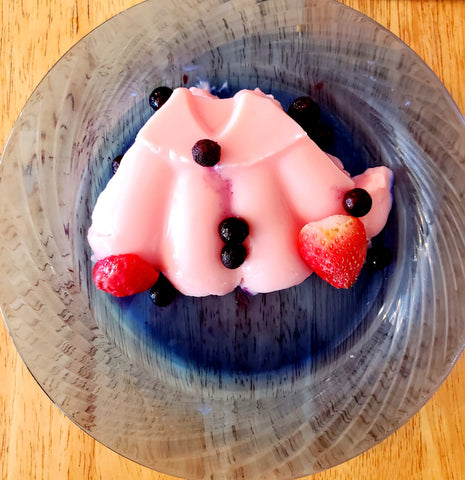 Strawberry Blancmange on a glass plate, topped with fruit