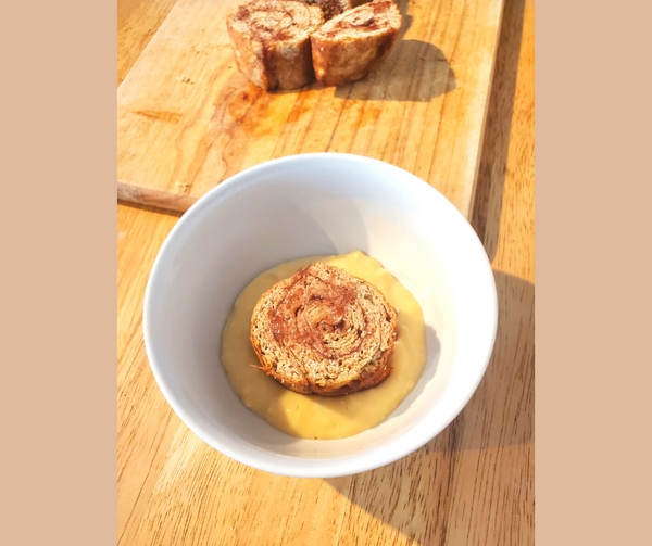 roly-poly in a white bowl of custard and roly-poly in background on a cutting board
