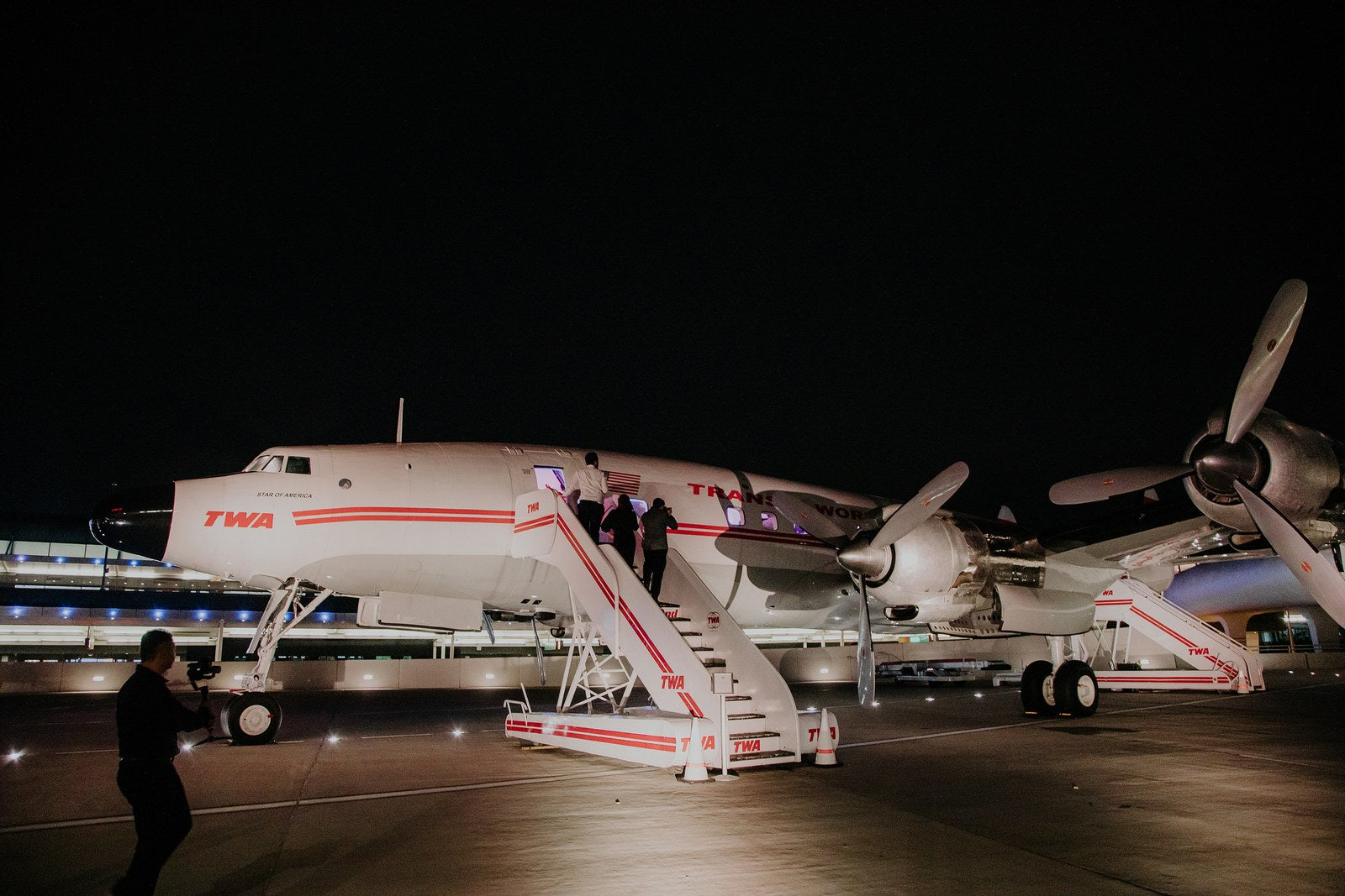 Image of wedding guests checking out a TWA airplane at the wedding, which was at the TWA Hotel in NYC.