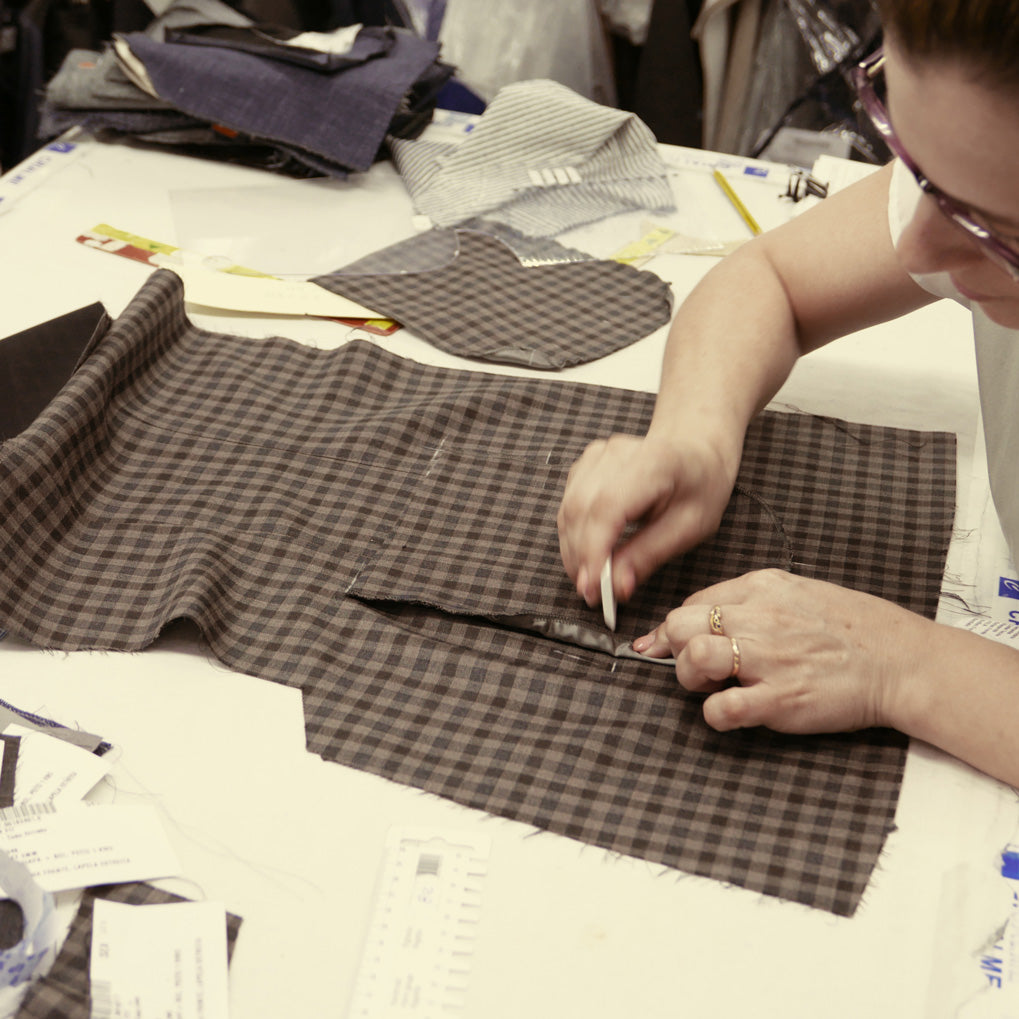 Tailor lining up the plaid patterns of the jacket when adding a pocket.