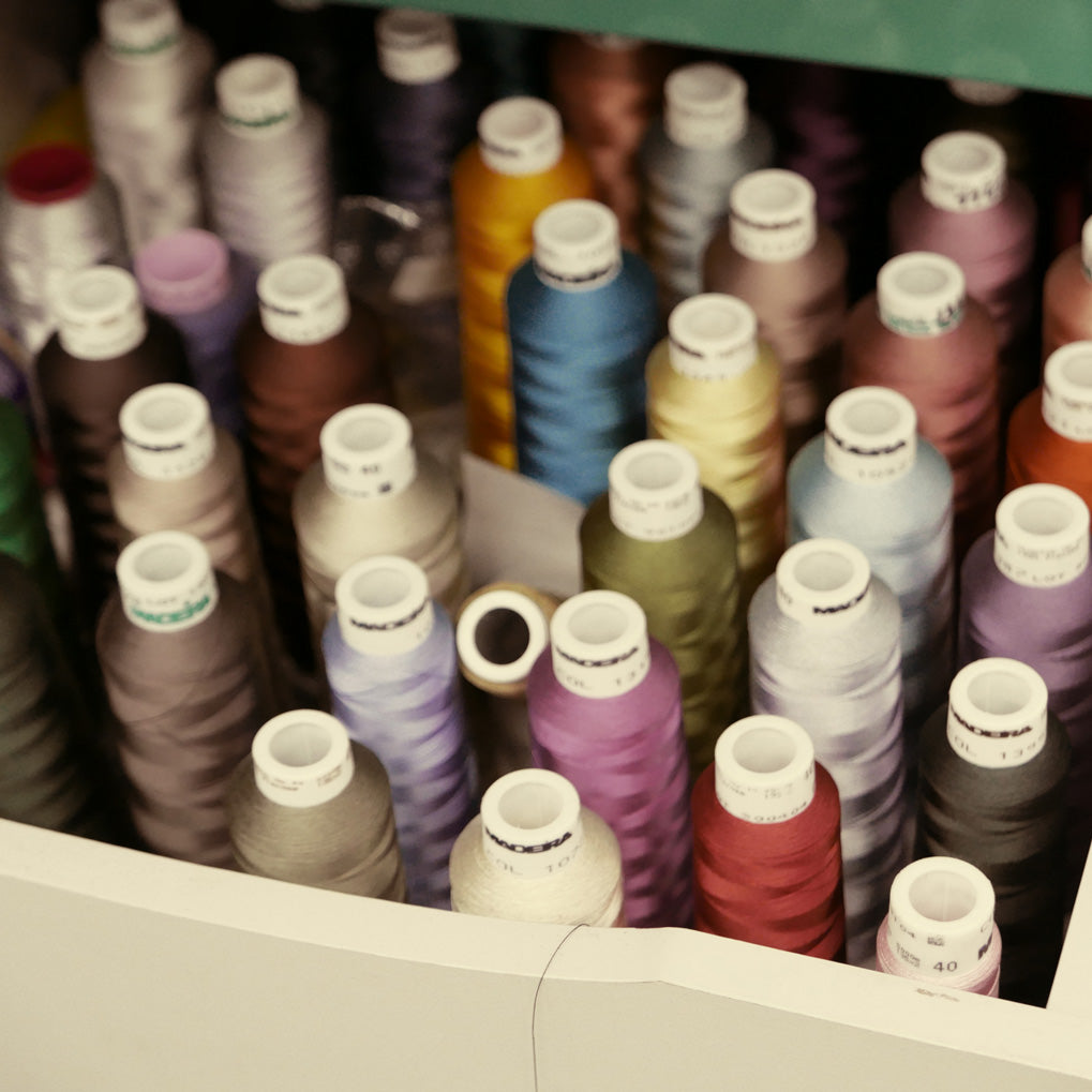 Close-up of many spools of colored thread.