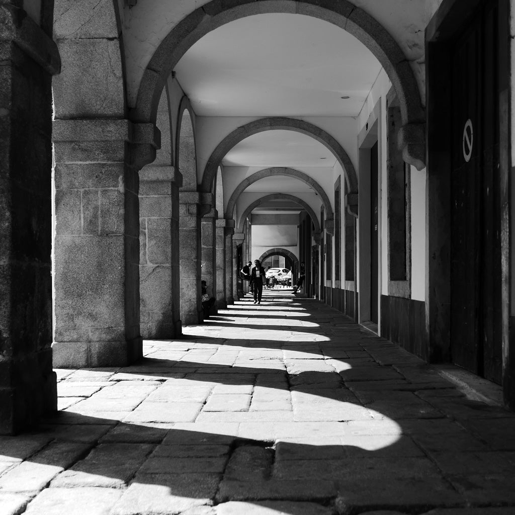 Black and white photo of a walkway with arches in Porto.