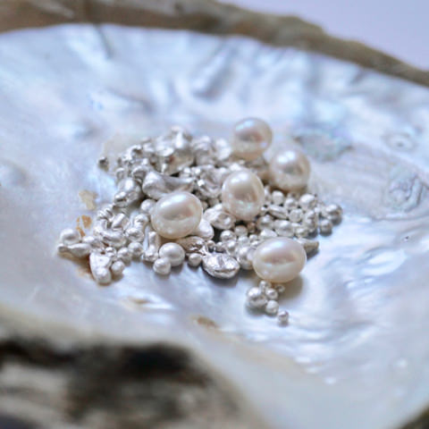 silver granules and pearls on oyster shell