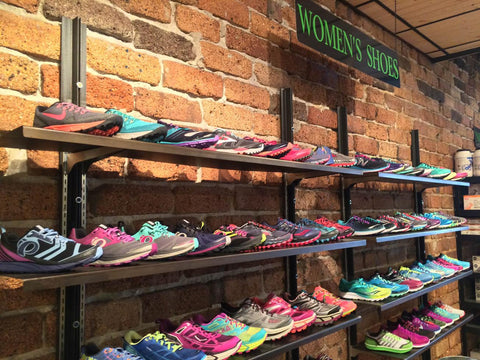 Bozeman Running Co Store's women shoes on shelves in front of a brick wall