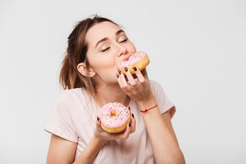 甘いドーナッツを食べる女性の写真