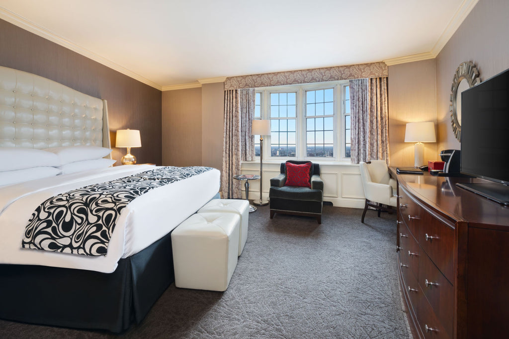 The interior of a guest room at The Pfister Hotel featuring a king-sized bed and elegant furnishings.