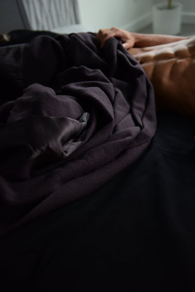 close up image of man lying in bed with the most luxurious henry black luxury king size blanket