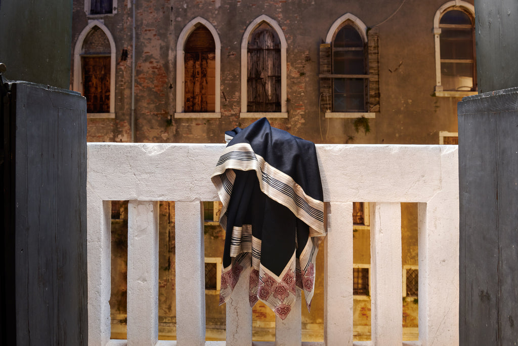 Now Voyager luxury throws and blankets hanging on a balcony in venice with windows in the background