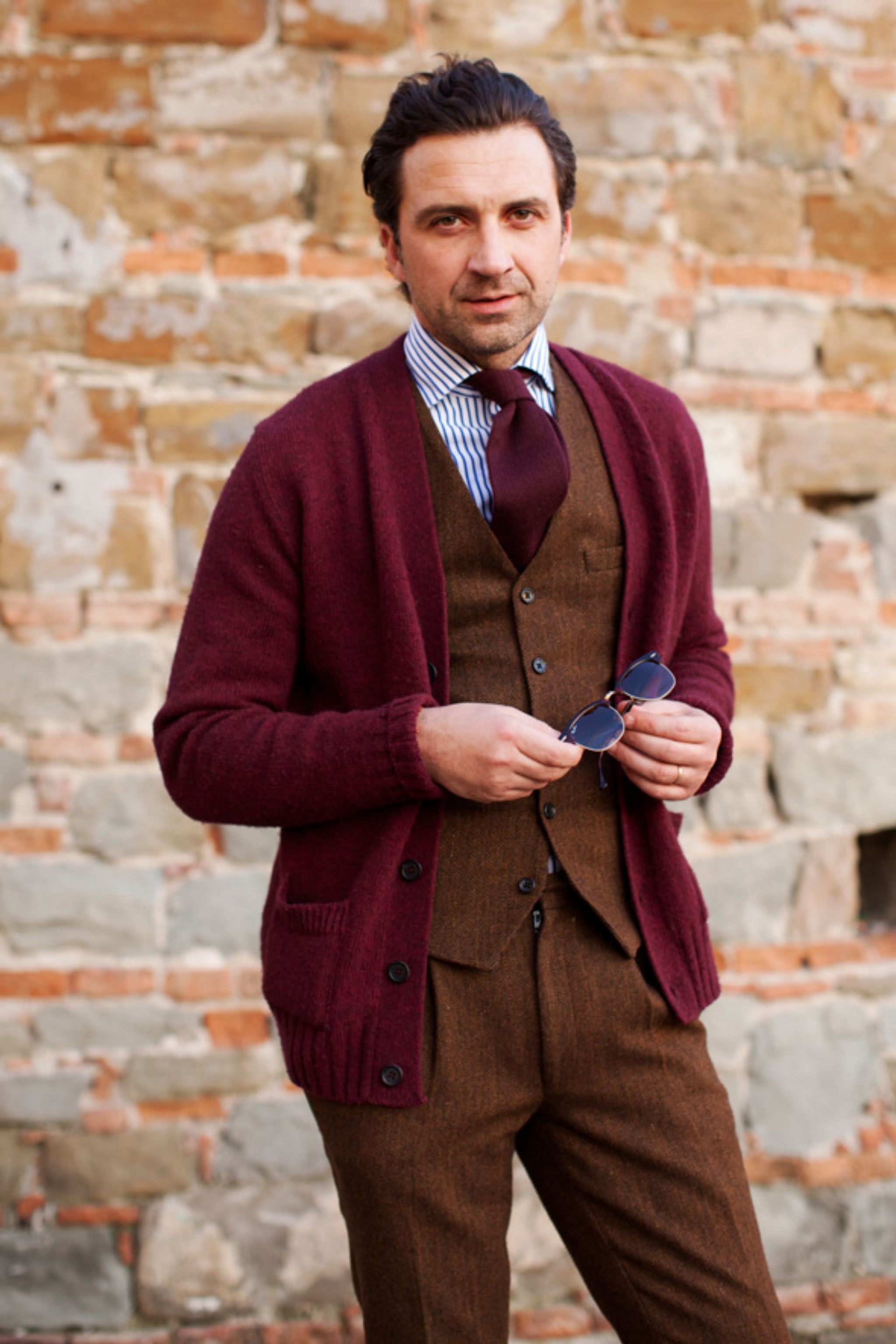 How about dressing down by replacing your three-piece suit jacket with a cardigan? Inspiring color-play with the tones of brown and burgundy. Pic by The Sartorialist.