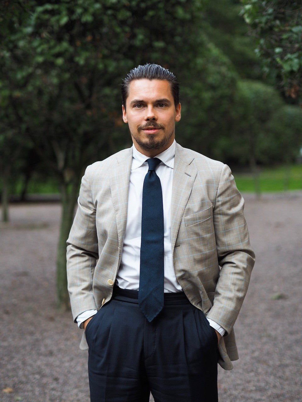 Navy suit trousers with checked sport coat and blue tie